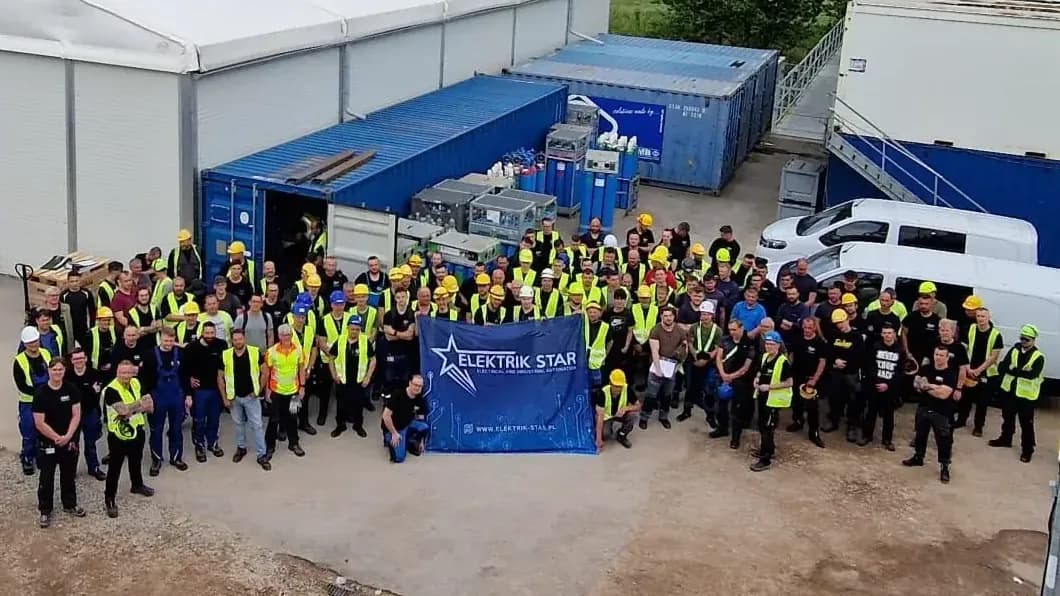 The Elektrik-Star crew with the company banner at a site compound, 2025