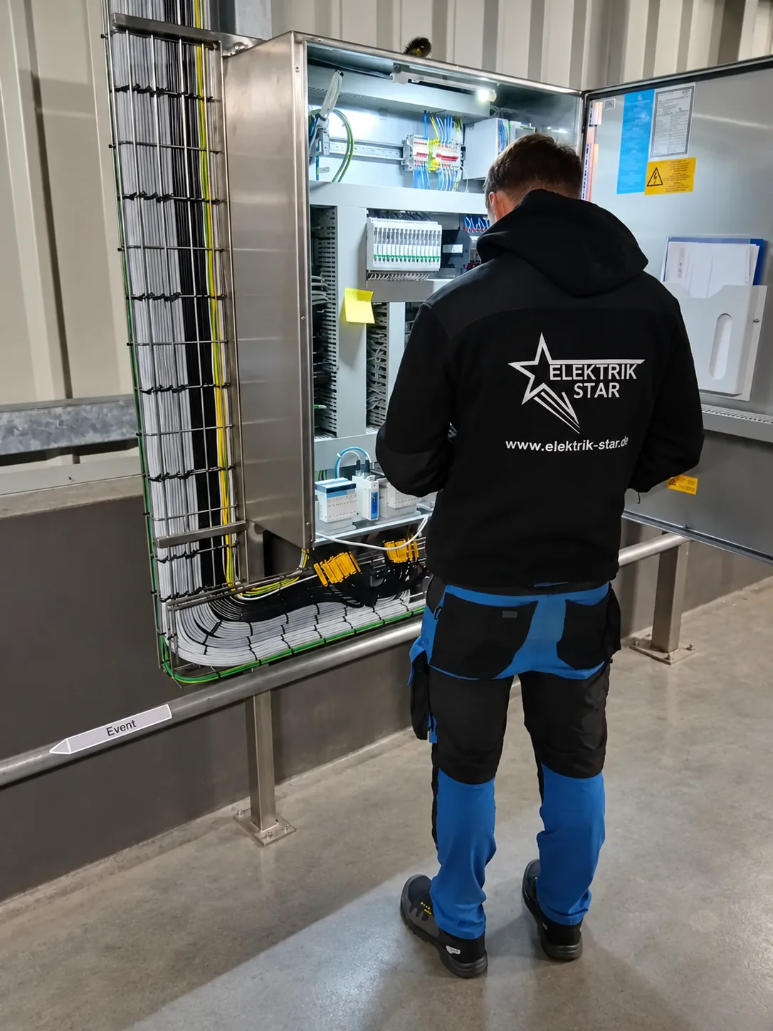 Elektryk Elektrik-Star podłącza szafę sterowniczą ze stali nierdzewnej