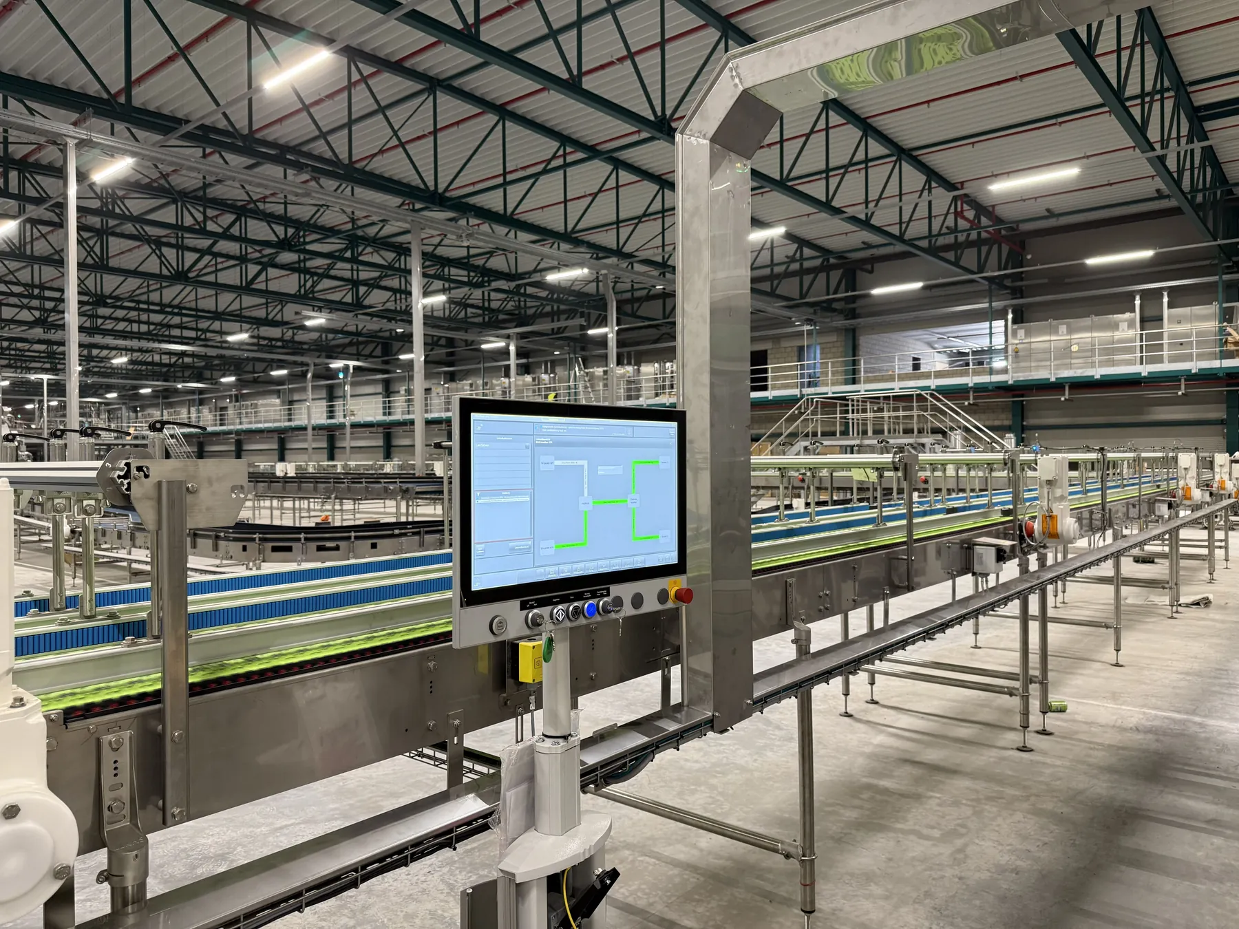 Linia z przenośnikami i panelem sterowania w hali produkcyjnej