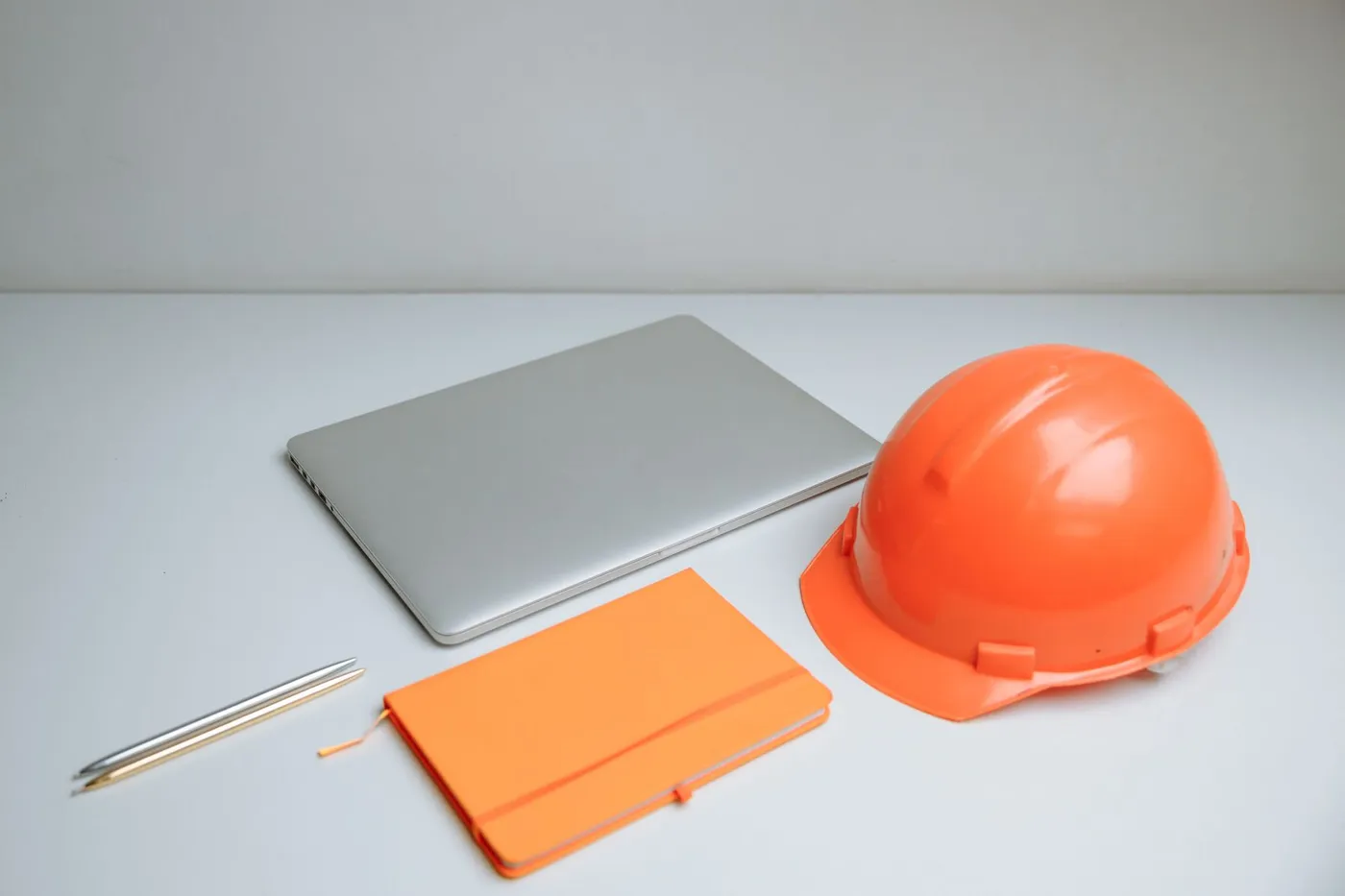 Laptop, kask i notes na biurku