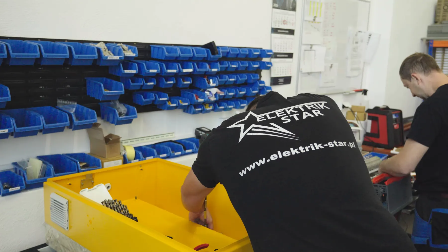 Monter w warsztacie Elektrik-Star przy stanowisku z częściami