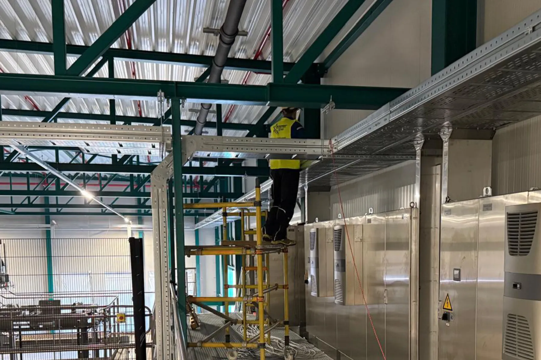 Production hall with scaffolding and cabinets next to the line