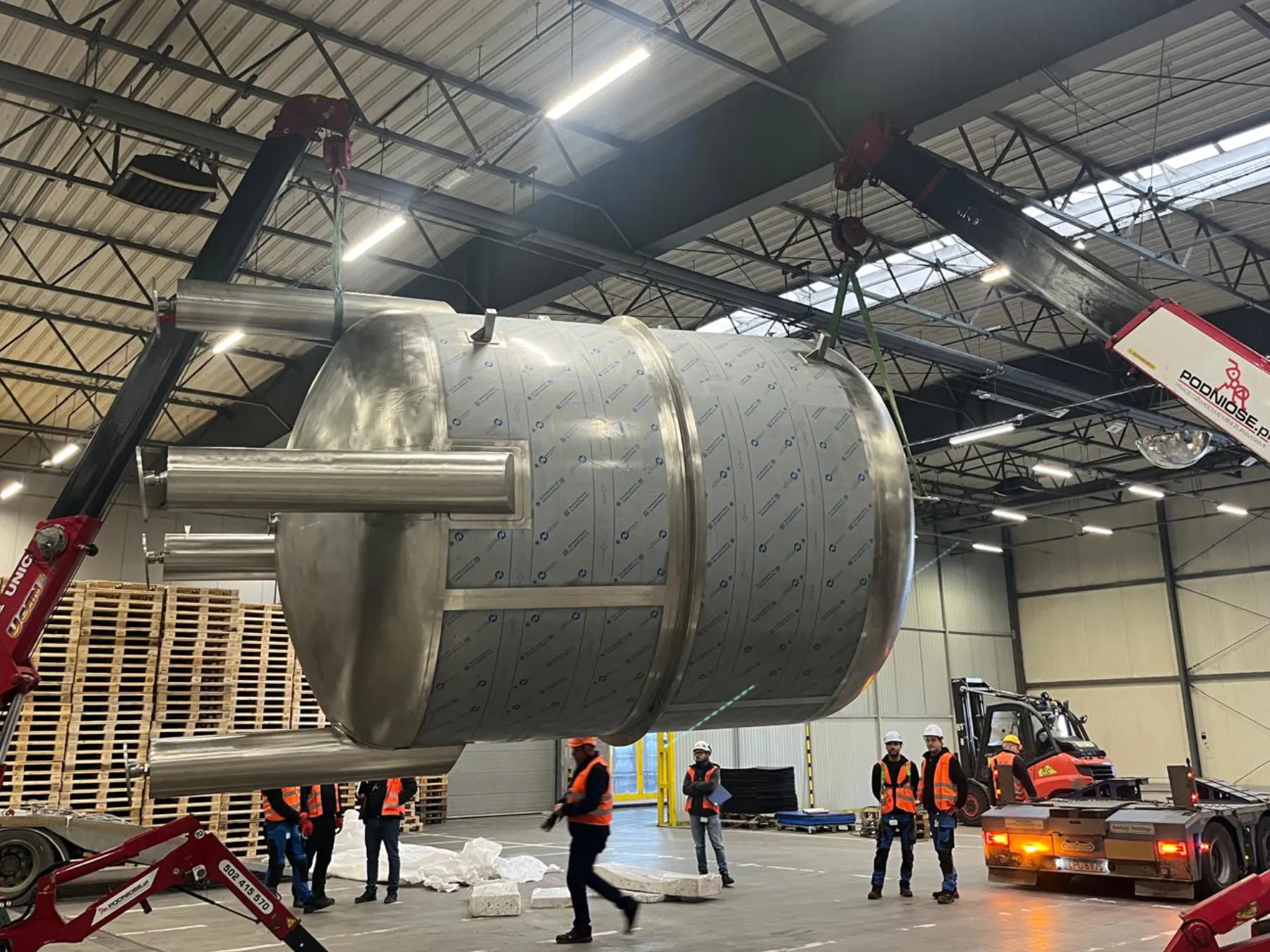 Stainless steel tank lifted by a crane in the hall, Okocim Brewery, Brzesko